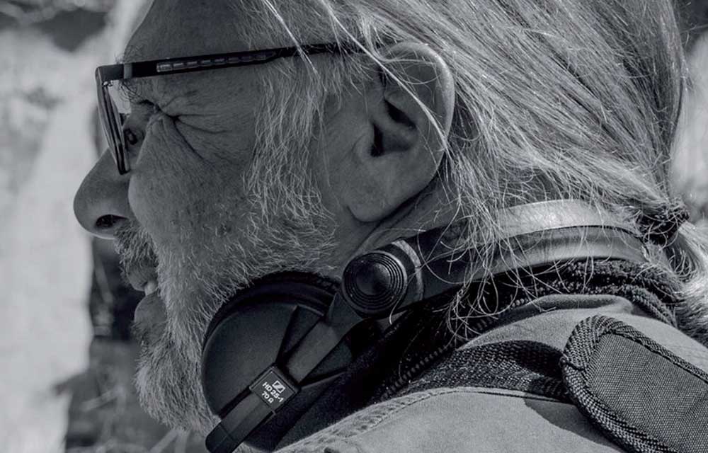 Der Autor Werner Cee mit einem Kopfhörer um den Hals.